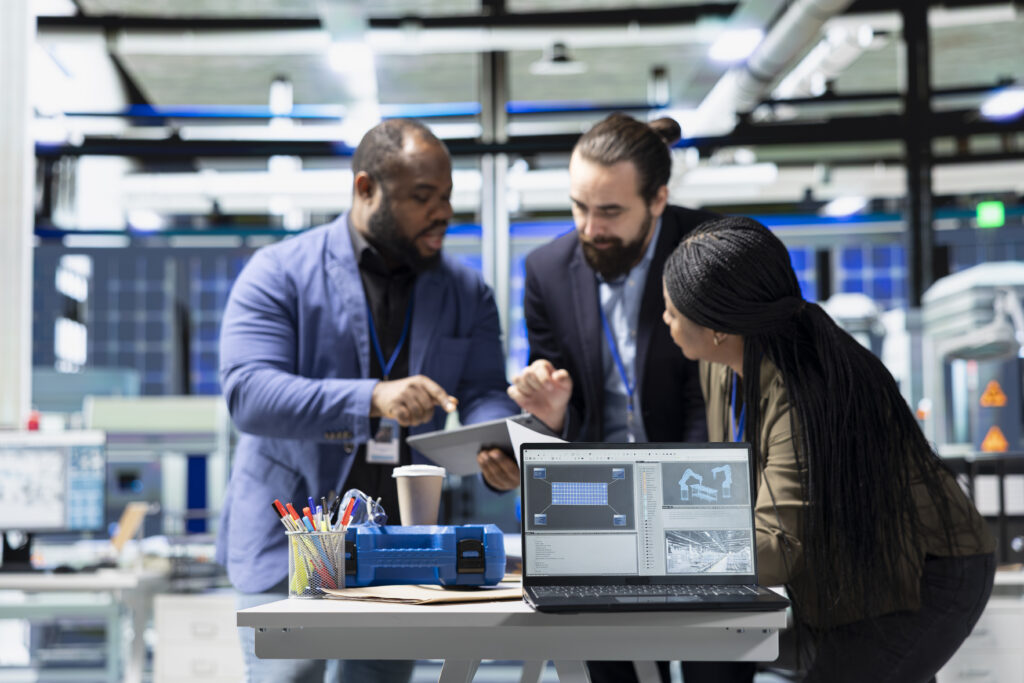 Multiethnic specialists engineers doing teamwork on modern production line