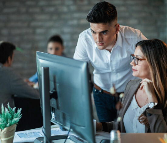 Young entrepreneurs cooperating wile working on a computer in the office.