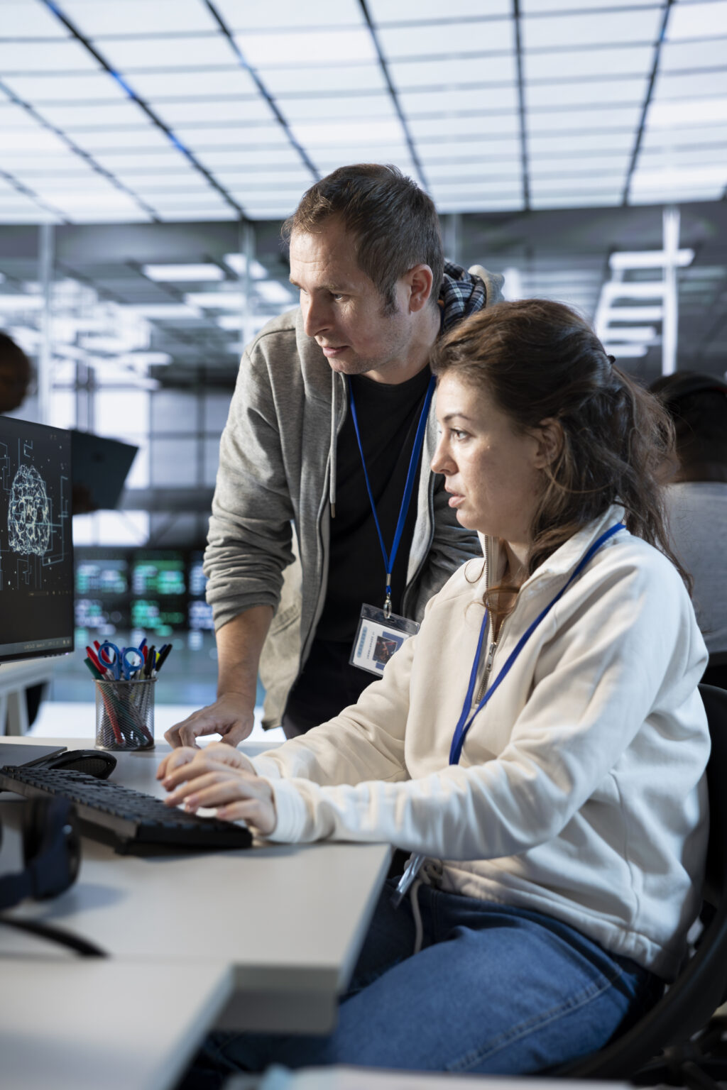 Worker requesting help from senior engineer to fix error in high tech data center